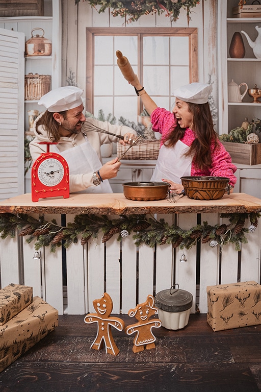 Ein Mann und eine Frau stehen in einer Spielzeugküche bei einem Weihnachtsminishooting und spielen wie als ob sie sich streiten