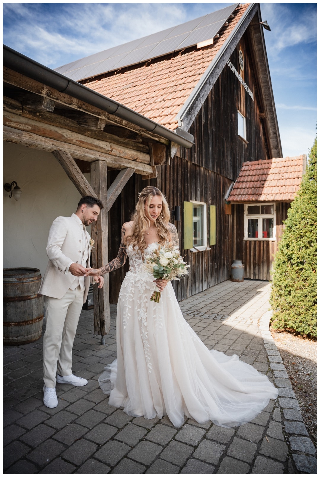 Der Bräutigam schaut sich das Kleid der Braut an Hochzeitsfotograf Ulm