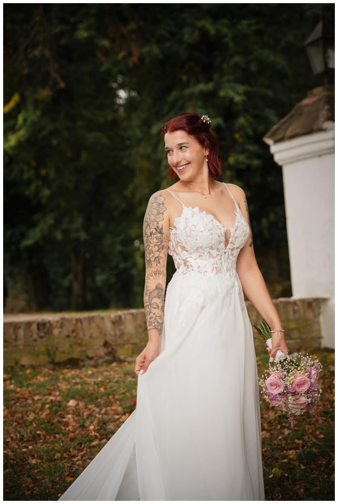 Eine Braut mit Tattoos und roten Haaren lachend Schloss Neuburg an der Kammel