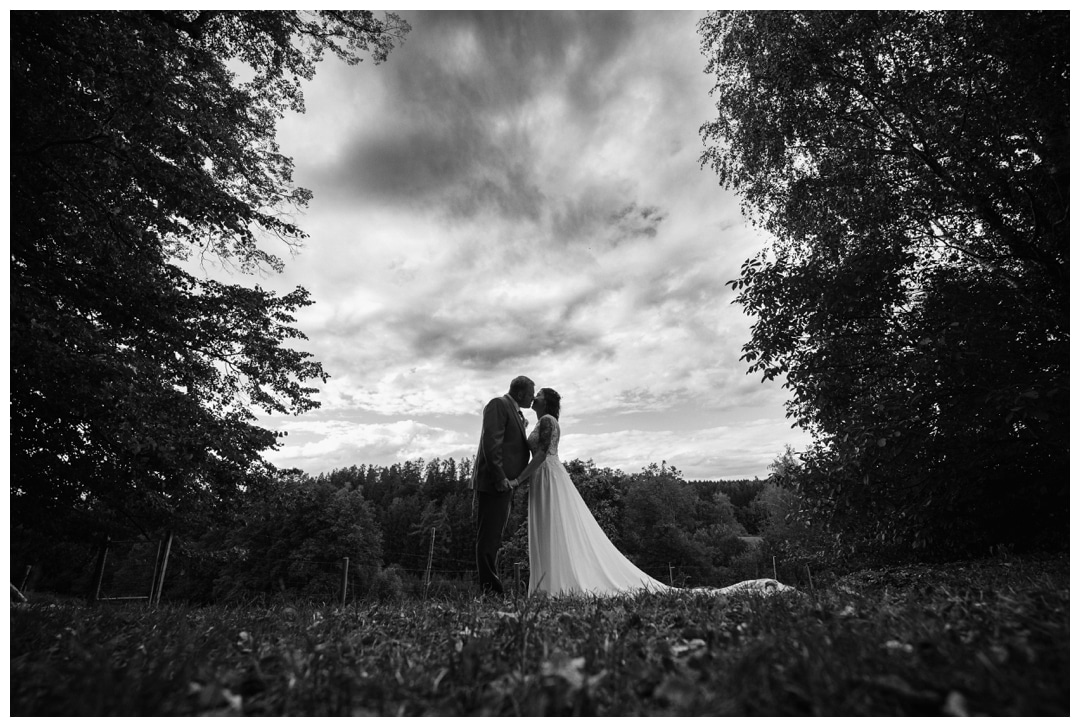 Ein weitwinkelfoto Schwarzweiss Schloss Neuburg an der Kammel Brautpaarfoto mit dunklem Himmel. Foto von Hochzeitsfotograf Ulm