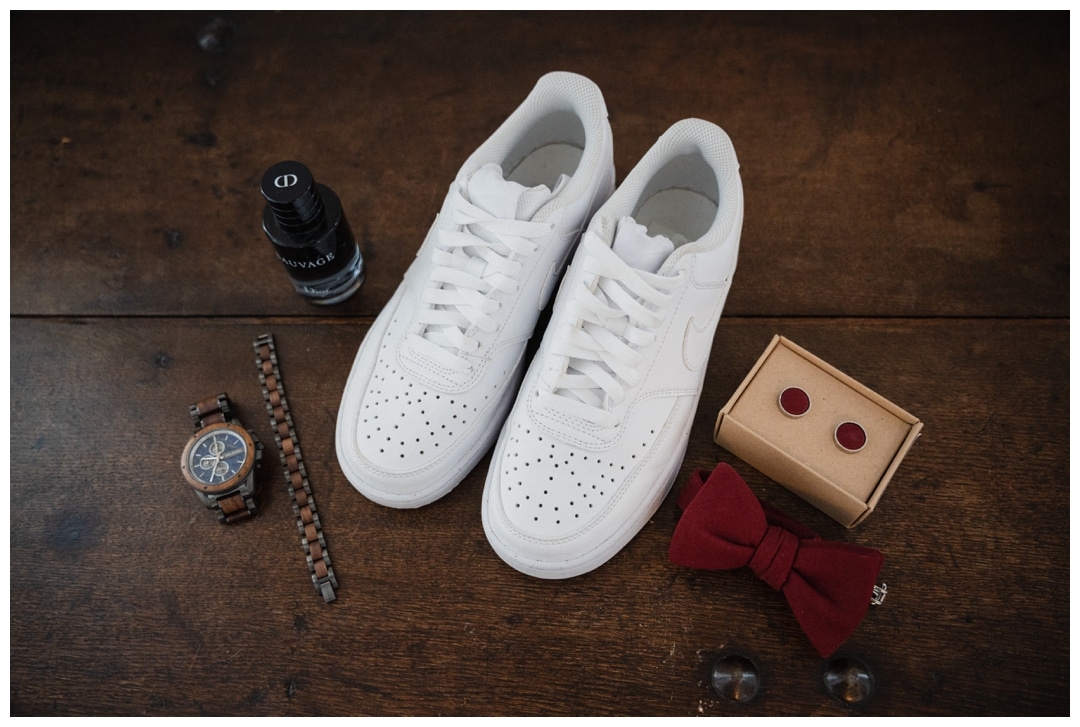 Weisse Schuhe zum Hochzeitsanzug. Getting-Ready Bild mit Schmuck und Fliege
