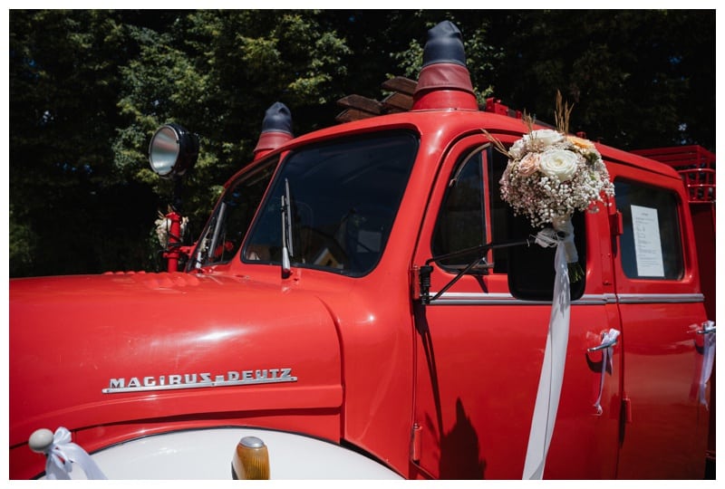 Ein mit Blumen geschmücktes Feuerwehrauto als Hochzeitsauto